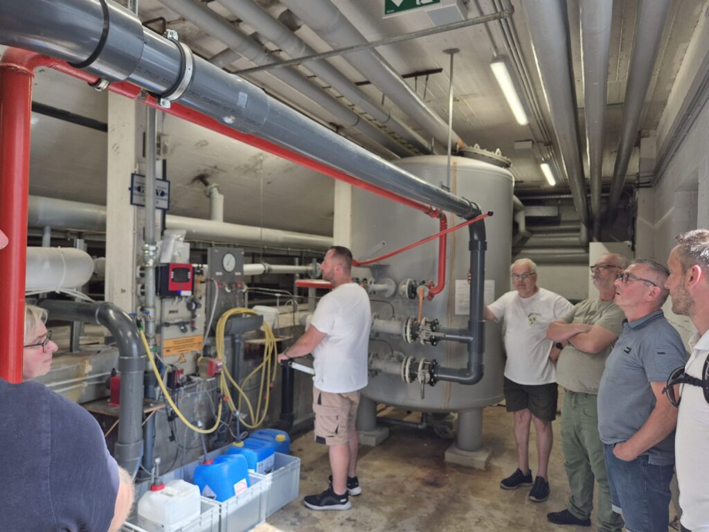 Teilnehmende des Ortstermins an der Filteranlage der Badewassertechnik des Lehrschwimmbeckens Faßberg