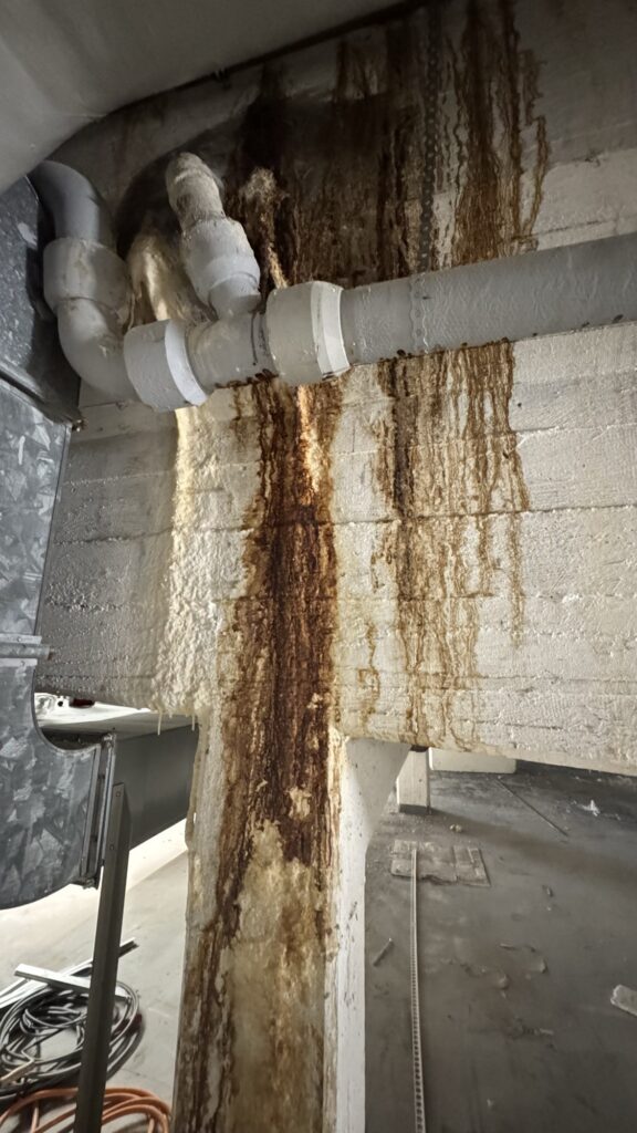 Deutliche Rost- und Ablaufspuren an Betonbauteilen und Leitungen im Technikbereich